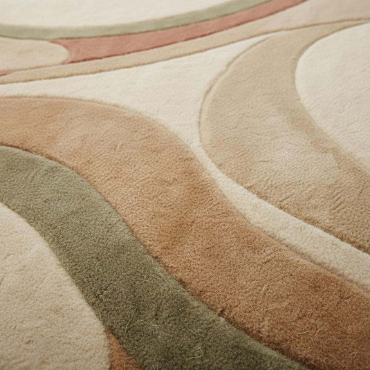 Translation missing: es.Close up of hand tufted high pile rug showing dense wool fibers, sculpted curves, plush texture, and detailed carving in cream and earthy tones