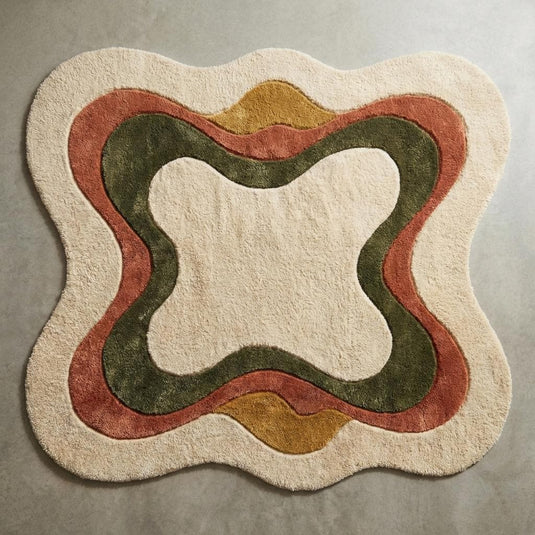 Translation missing: es.Top-down view of irregular shaped abstract area rug with curved earth tone pattern on cream background, modern boho sculpted carpet design fully visible