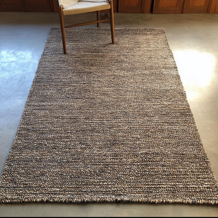 Translation missing: es.Textured wool rug with dense woven pattern in warm neutrals, modern minimalist home décor floor rug under wooden chair