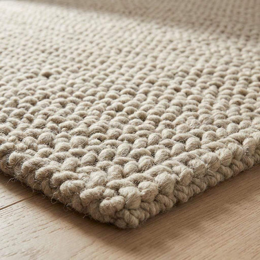 Translation missing: es.Chunky braided knit rug in neutral beige with thick textured yarn ideal for cozy Nordic interiors