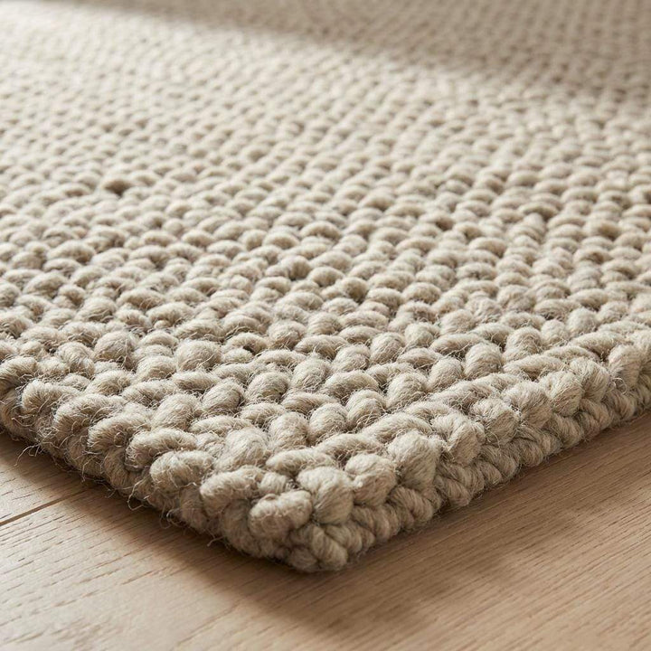 Translation missing: es.Chunky braided knit rug in neutral beige with thick textured yarn ideal for cozy Nordic interiors
