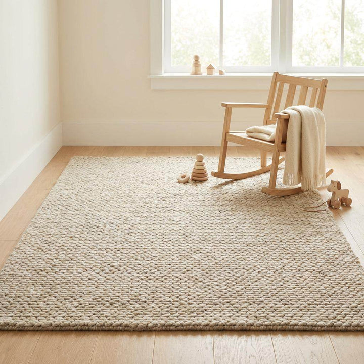 Translation missing: es.Chunky braided knit rug in neutral beige with thick textured yarn for cozy Nordic interiors