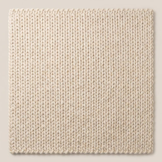 Translation missing: es.Macro shot highlighting the plush braided construction of a neutral cream textured rug
