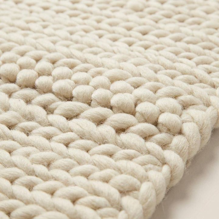 Translation missing: fr.Chunky knit area rug with thick, textured neutral yarn, adding cozy warmth and modern organic style to floors