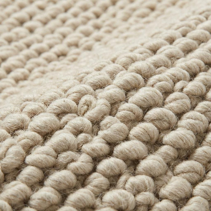 Translation missing: es.Chunky knit neutral rug with thick oversized loops and warm textured natural fibers for cozy Scandinavian interiors
