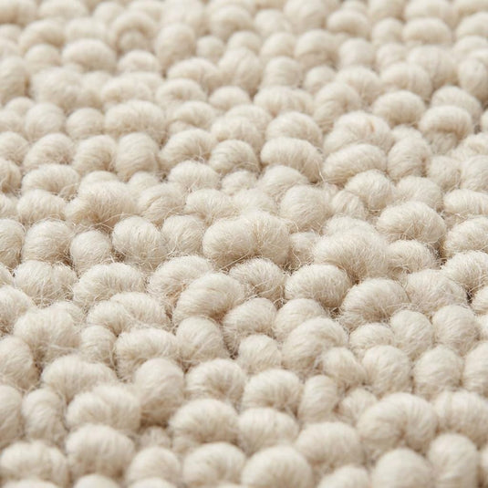Translation missing: es.Close-up of chunky wool rug showing thick looped fibers, handwoven texture, and soft natural wool roving detail in ivory color with plush tactile finish