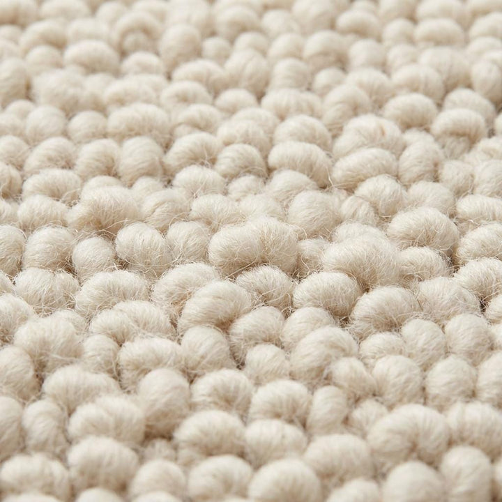 Translation missing: es.Close-up of chunky wool rug showing thick looped fibers, handwoven texture, and soft natural wool roving detail in ivory color with plush tactile finish