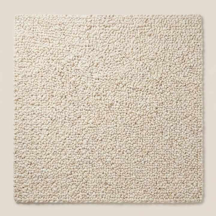 Translation missing: es.Top-down view of ivory chunky knit area rug highlighting dense loop texture, full surface coverage, and modern minimalist solid design