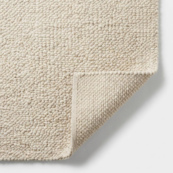 Translation missing: es.Detailed view of rug edge showing thick handwoven loops and durable wool construction, highlighting chunky knit craftsmanship and premium finish