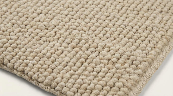 Translation missing: es.Cream beige chunky knit wool rug styled in a cozy living room with natural light