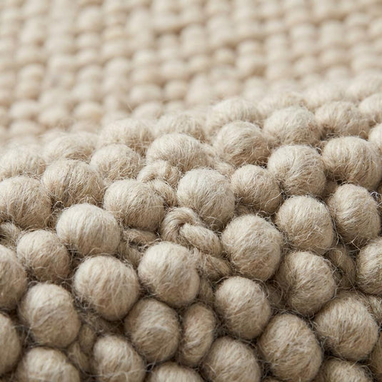 Translation missing: es.Close-up of thick looped nubby texture on neutral cream area rug