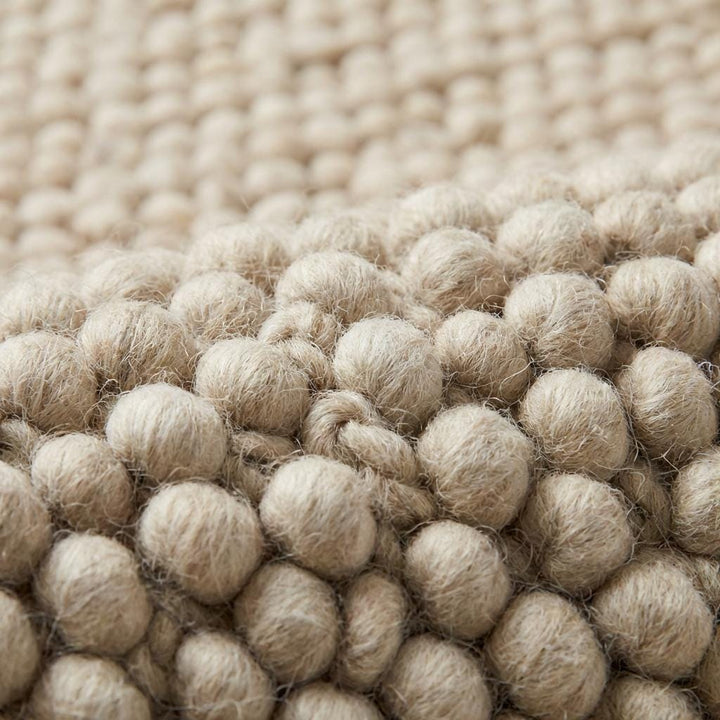 Translation missing: es.Close-up of thick looped nubby texture on neutral cream area rug