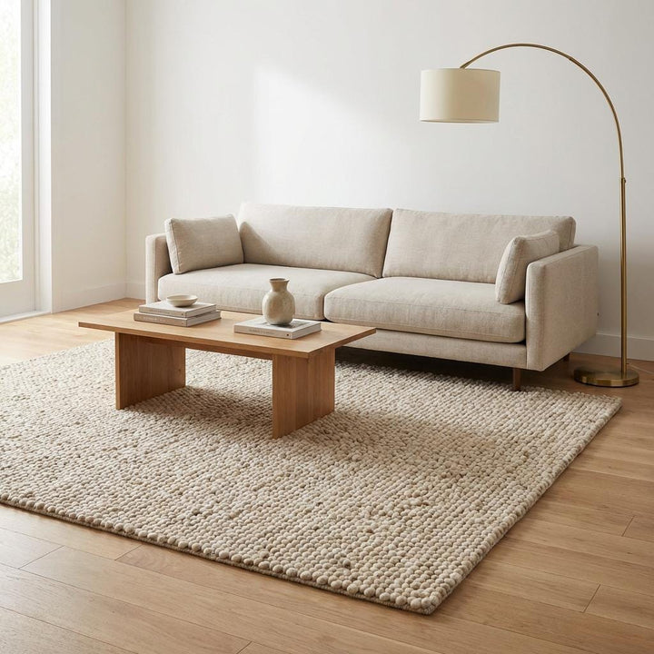 Translation missing: es.Soft cream textured rug creating a cozy minimalist bedroom or reading nook setting