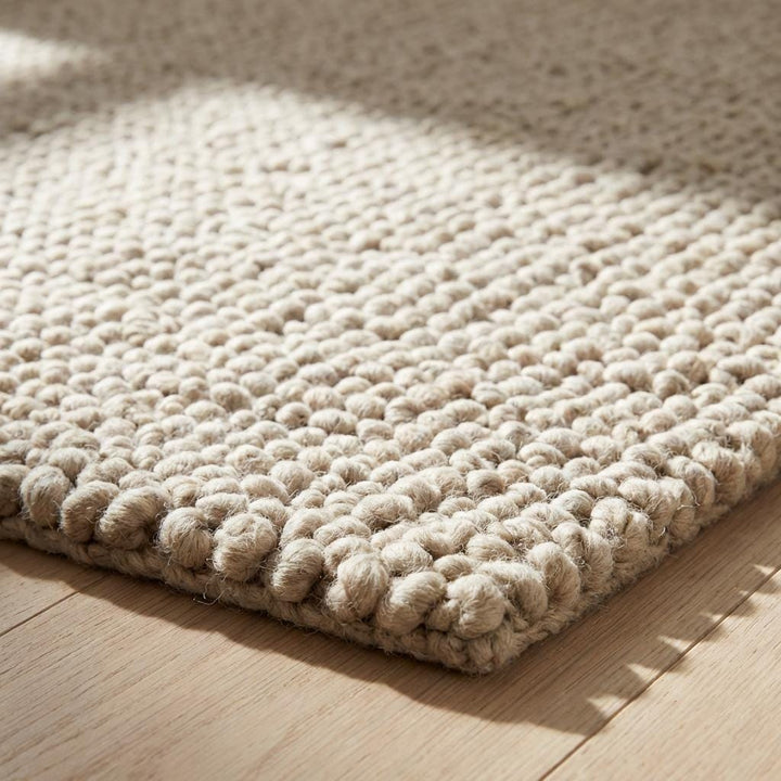 Translation missing: en.Detailed edge view of dense loop construction in textured beige rug
