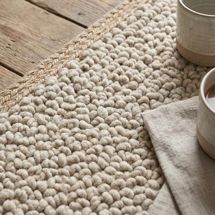 Translation missing: es.Chunky loop textured neutral area rug with dense nubby surface and braided edge detail for modern organic interiors