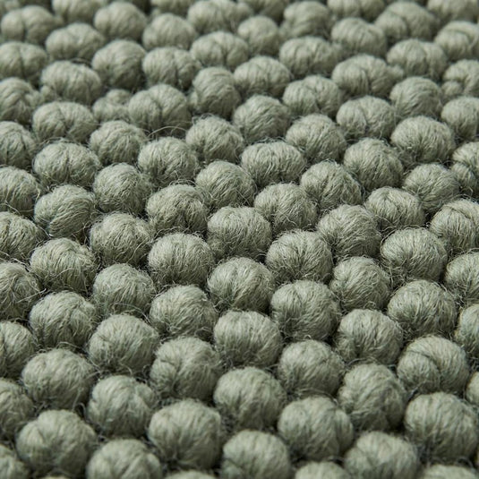 Translation missing: es.Close up of thick loop yarn texture on sage green minimalist rug