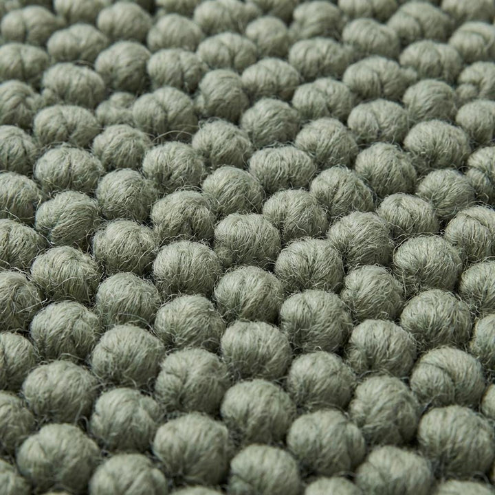 Translation missing: en.Close up of thick loop yarn texture on sage green minimalist rug