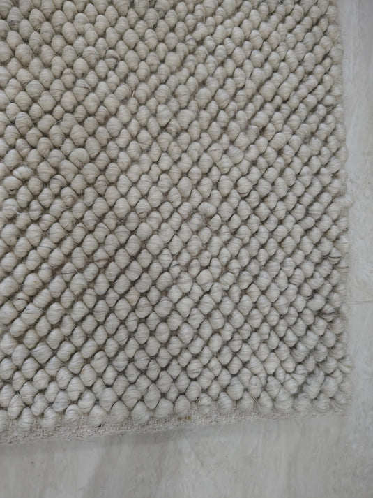 Translation missing: es.Detailed texture view of dense cream loop rug with sculpted surface