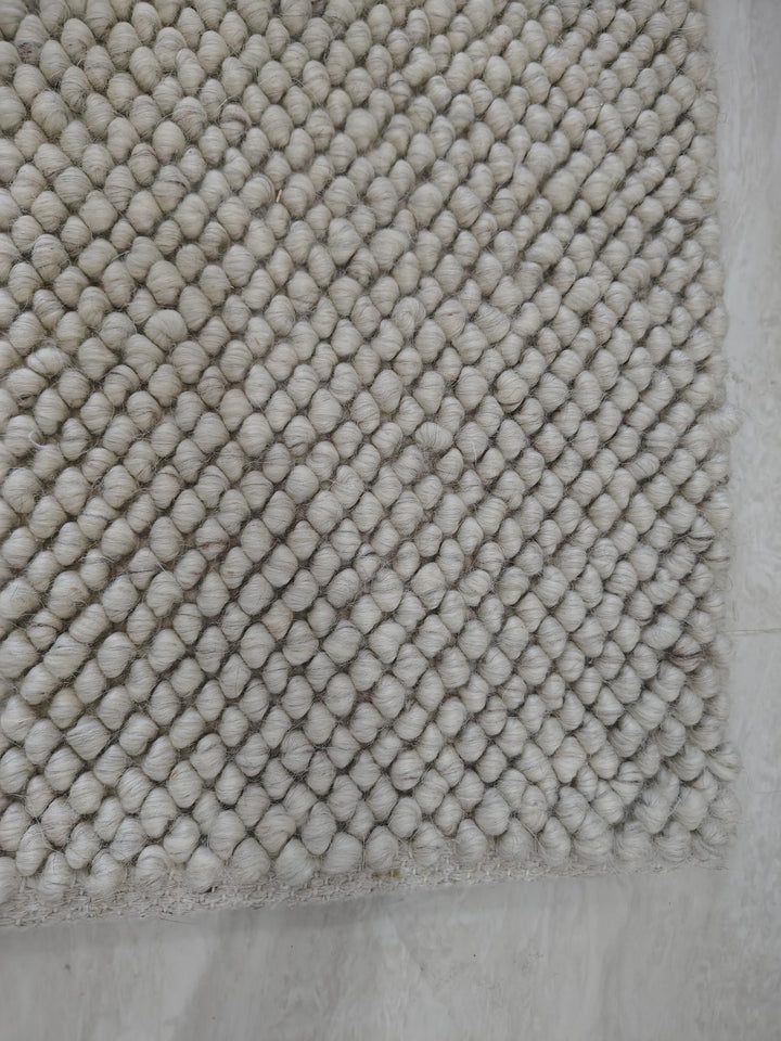 Translation missing: es.Detailed texture view of dense cream loop rug with sculpted surface