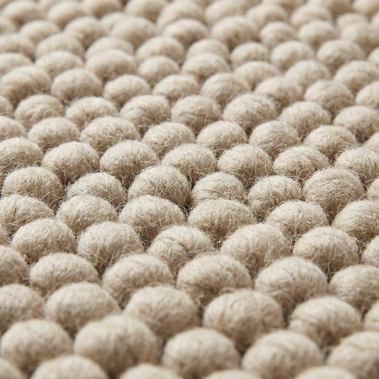 Translation missing: es.Close-up of thick pebble-textured neutral rug showing dense yarn clusters