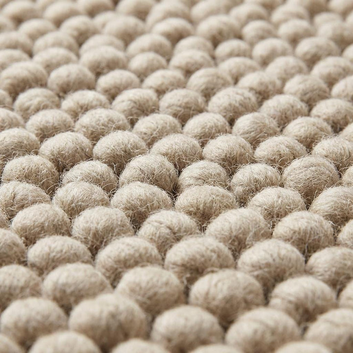Translation missing: es.Close-up of thick pebble-textured neutral rug showing dense yarn clusters