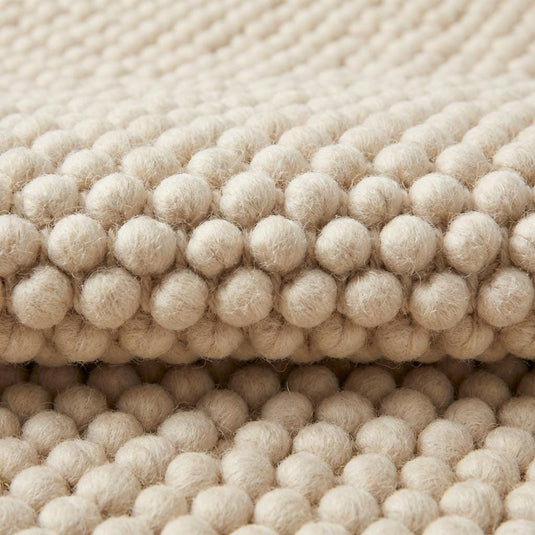 Translation missing: es.Chunky textured neutral area rug with thick looped plush surface in cozy living room setting