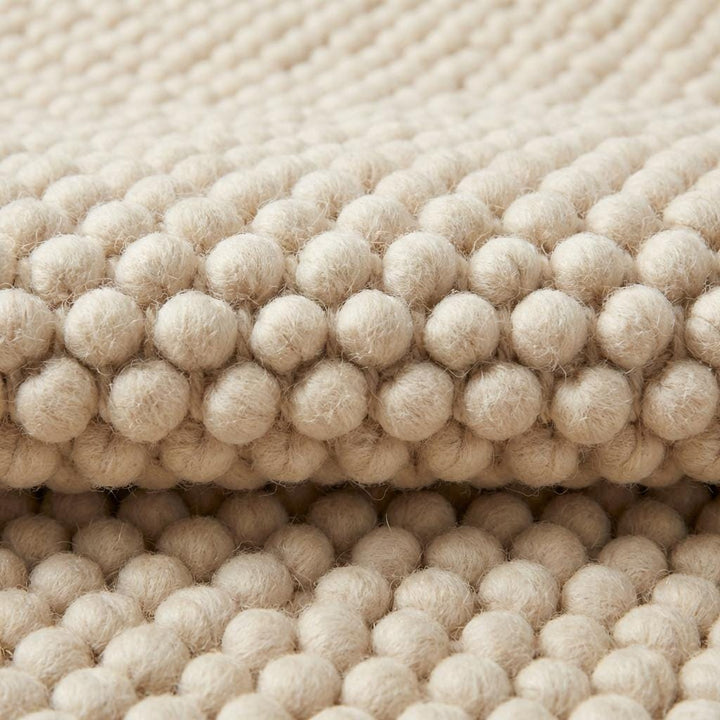 Translation missing: es.Chunky textured neutral area rug with thick looped plush surface in cozy living room setting