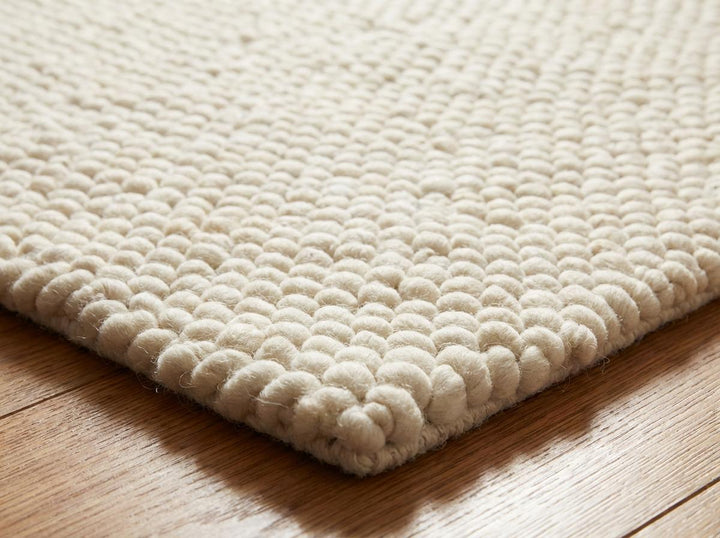 Translation missing: es.Chunky wool ivory area rug with thick textured loops in Scandinavian neutral living room setting