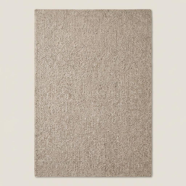 Translation missing: es.Top-down view of solid neutral chunky rug showcasing full texture and looped weave pattern, minimalist beige area rug with thick woven construction