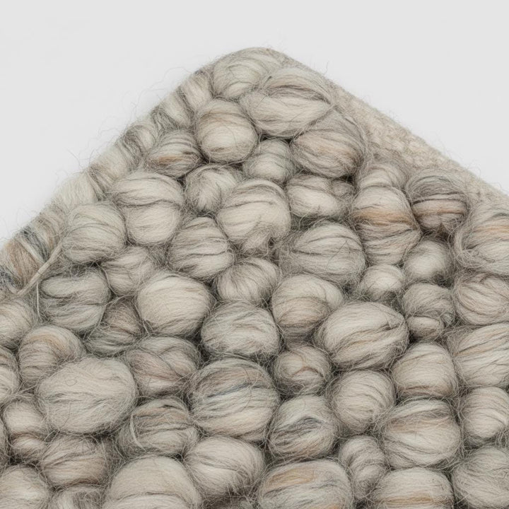Translation missing: es.High-quality natural wool rug in textured loops, close-up showing soft neutral color palette for Scandinavian interiors