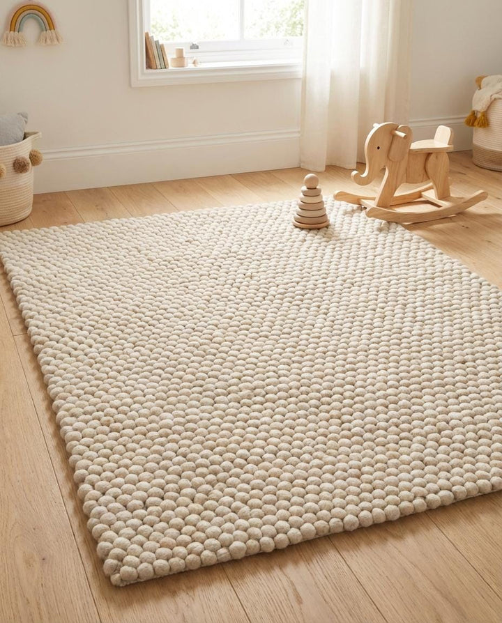 Translation missing: es.Soft wool pom pom area rug close-up showing plush texture ideal for cozy bedroom or nursery decor