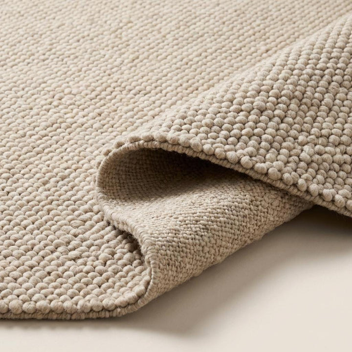 Translation missing: es.Detailed edge view of thick wool rug showing dense construction, clean finishing, and plush loop pile thickness for durability