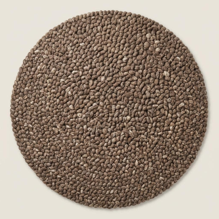 Translation missing: es.Neutral chunky wool area rug under accent chair with sunlight highlighting thick woven texture