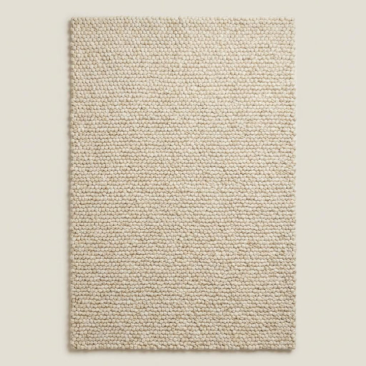 Translation missing: es.Handwoven chunky wool area rug with textured loop pile in soft neutral cream tone for Scandinavian minimalist interior design