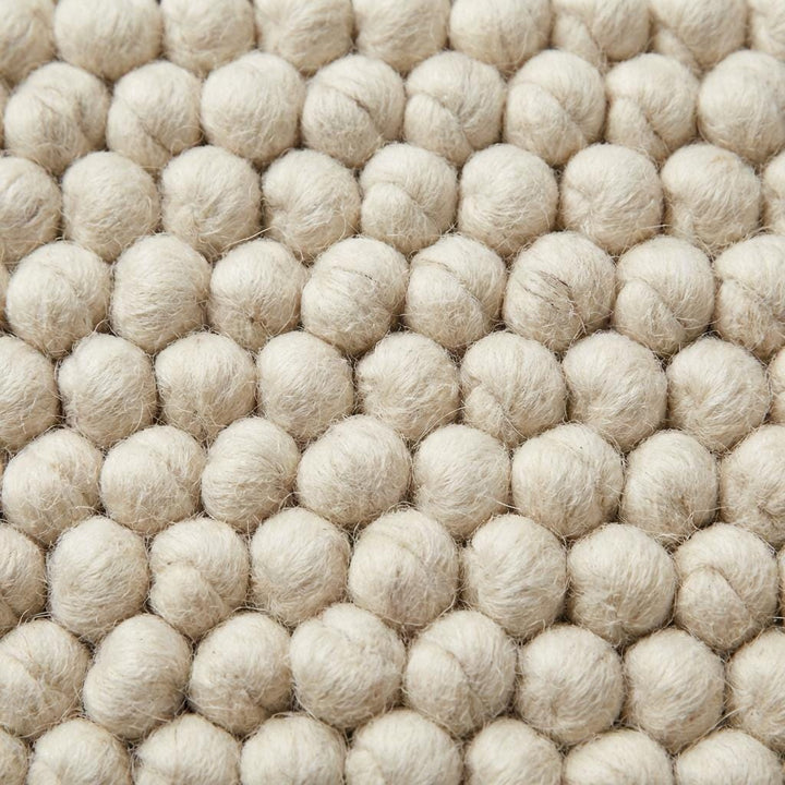Translation missing: es.Handwoven chunky wool rug with textured weave, minimalist Scandinavian home interior style