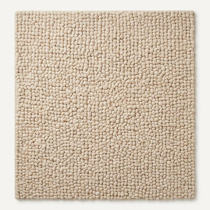 Translation missing: es.Handmade chunky knit wool rug soft plush texture close-up for cozy home decor styling