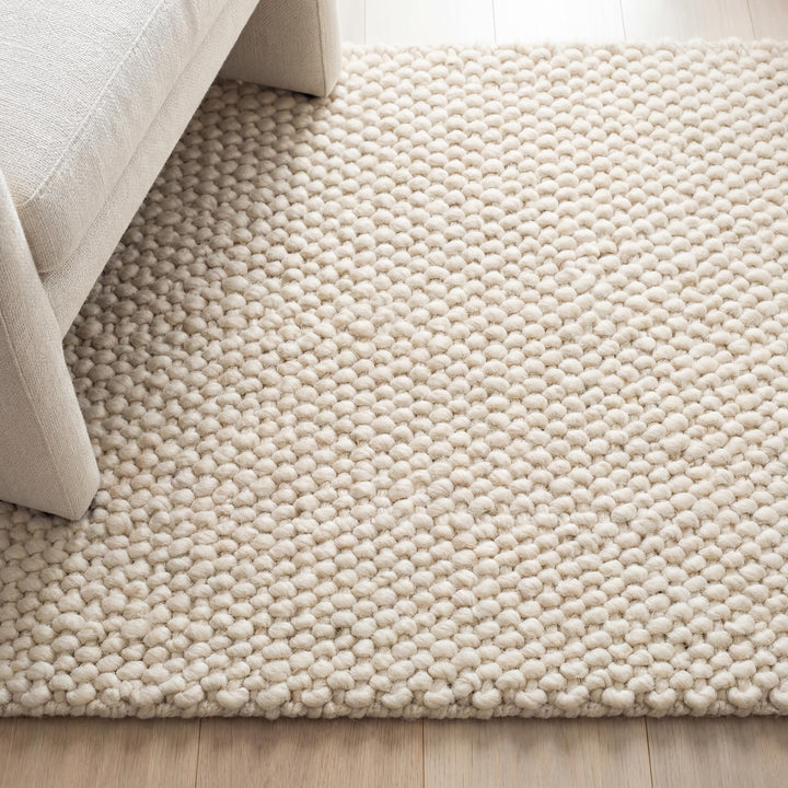 Translation missing: es.Chunky wool rug with neutral tones and soft loop pile texture in minimalist living room