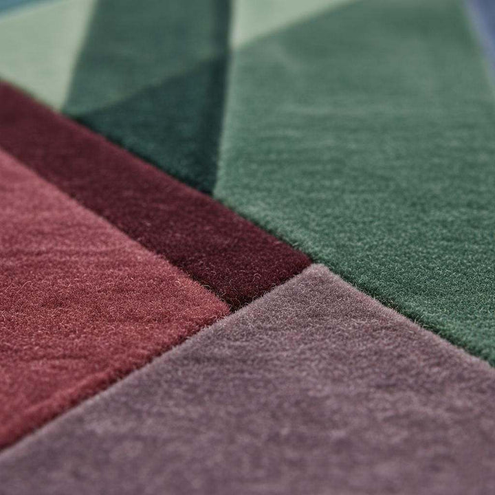 Translation missing: en.Close-up of bold triangle and rectangle shapes in burgundy, teal, and lavender on a geometric rug