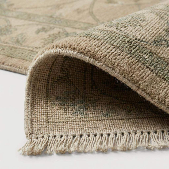 Translation missing: en.Close-up of the hand-knotted wool fibers showing the intricate knot structure, natural wool texture, and subtle sage green and tan yarn variations