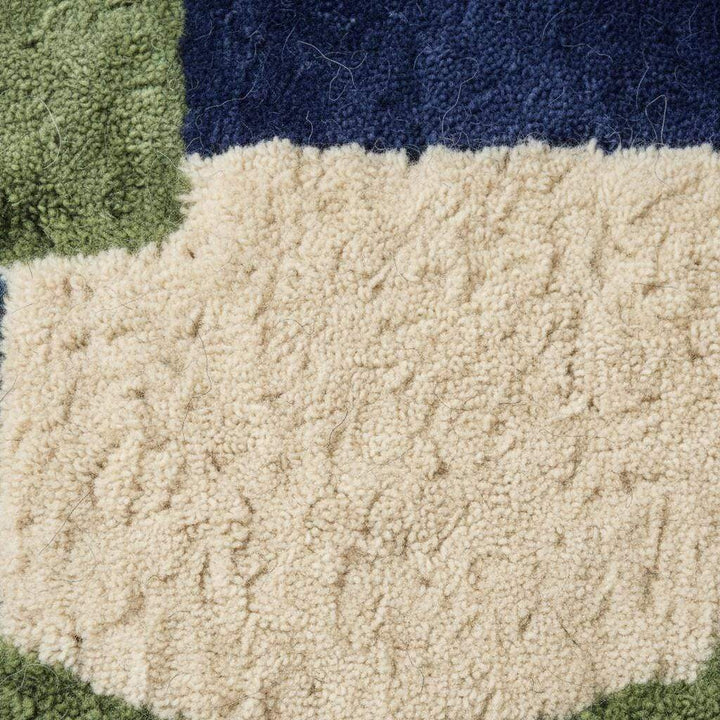 Translation missing: en.Hand tufted rug with bold blue and green geometric design, soft wool texture, and plush pile for mid-century modern decor
