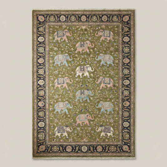 Translation missing: es.Traditional elephant pattern rug with navy ornamental border on wooden floor interior