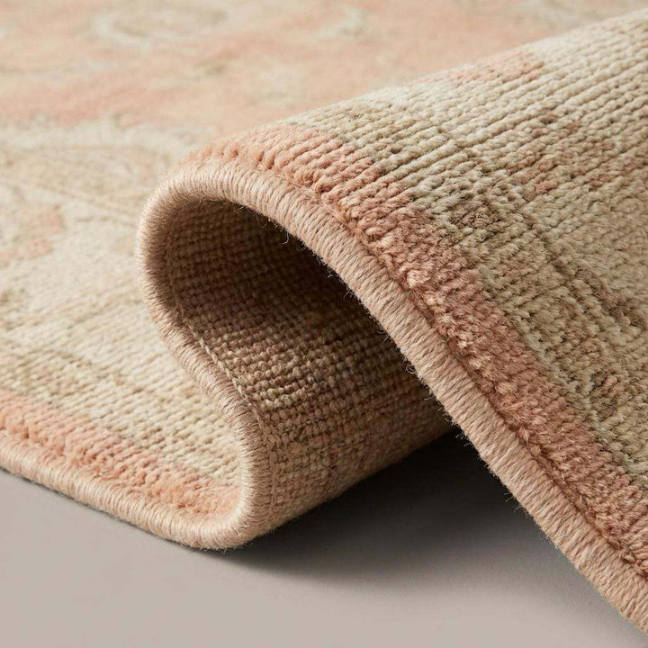 Translation missing: en.Close-up of dense hand-knotted wool pile showing soft peach fibers, individual knot texture, and natural artisanal weave detail
