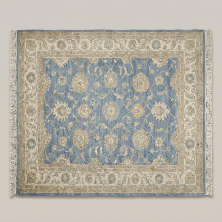 Translation missing: es.Blue and beige traditional wool rug styled beside a chair in a bright corner space __etsy:7982606684