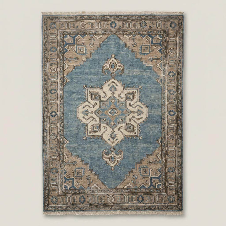 Translation missing: en.Traditional blue medallion Oushak area rug on wooden floor beside leather armchair and linen curtains