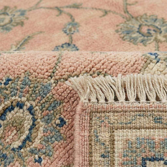 Translation missing: es.Close up of hand knotted wool pile showing individual knots and soft floral vine pattern
