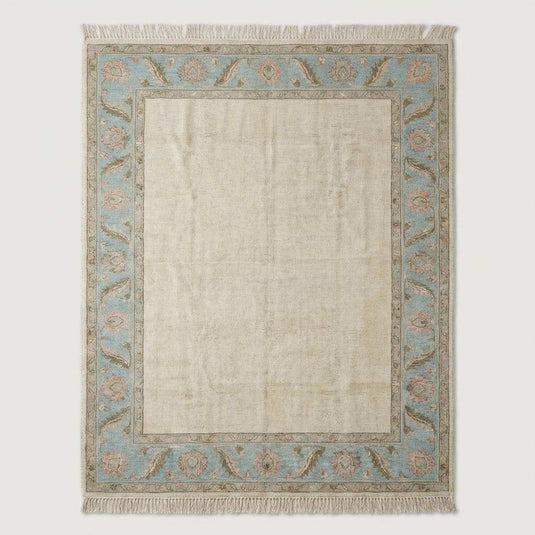 Translation missing: es.Neutral ivory and blue handmade wool area rug styled under modern accent chair near arched window