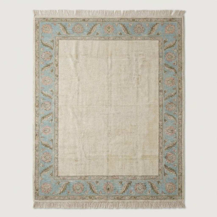 Translation missing: es.Neutral ivory and blue handmade wool area rug styled under modern accent chair near arched window