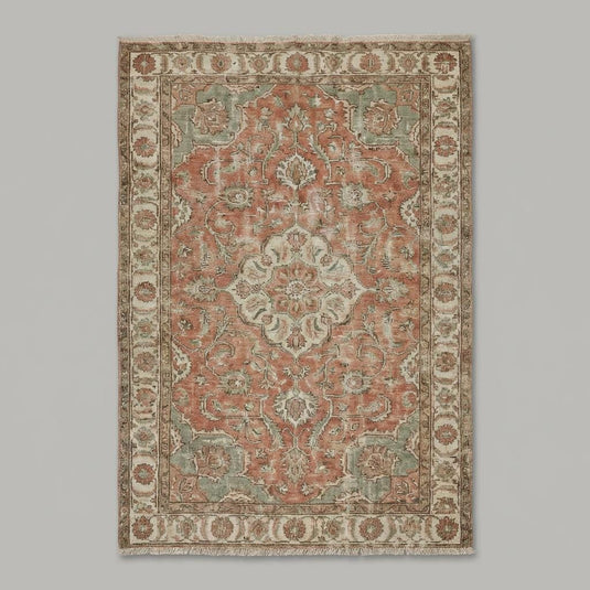 Translation missing: es.Intricate floral border detail of the Turkish rug showing terracotta, olive, and cream color variations