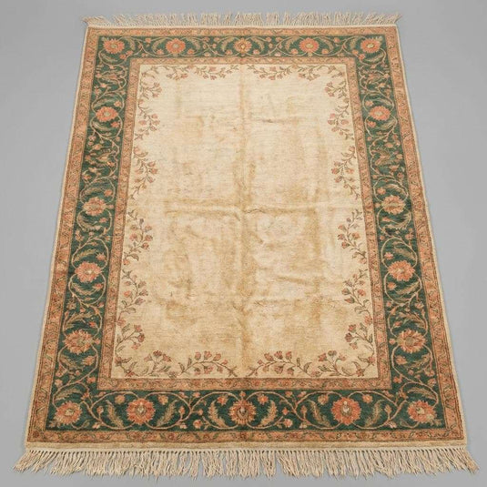 Translation missing: es.Muted green and terracotta traditional area rug styled in a bright room with a velvet armchair