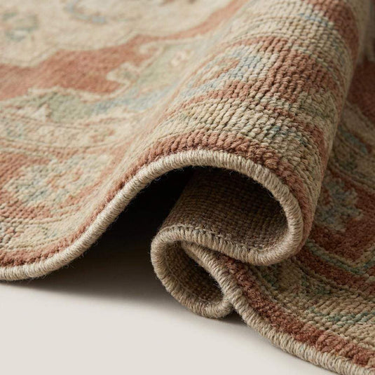 Translation missing: es.Close up detail of hand knotted wool pile showing individual knots, muted yarn colors, and soft texture without latex backing